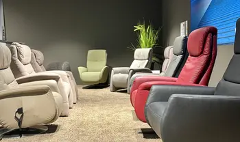 Ausstellung mit mehreren Relaxsesseln in verschiedenen Farben und Formen, präsentiert in modernem Showroom mit gedämpfter Beleuchtung und wohnlichem Ambiente.